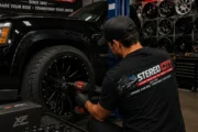 Technician fitting a custom wheel and tire Technician fitting a custom wheel and tire